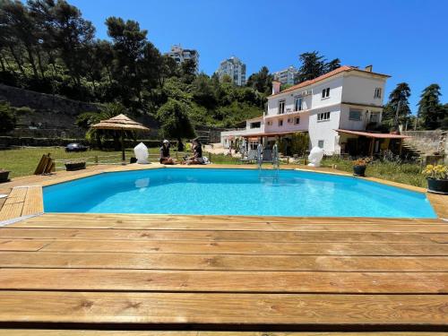 a swimming pool in front of a house at Quinta da Villa in Cascais