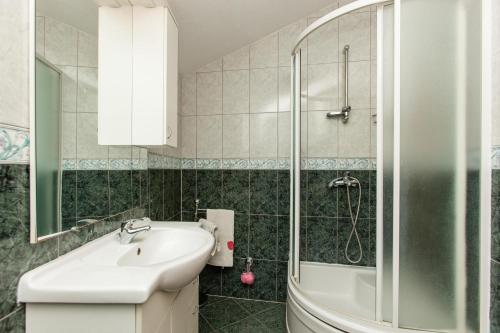 ein Bad mit einem Waschbecken und einer Dusche in der Unterkunft Holiday Home Beata in Trogir