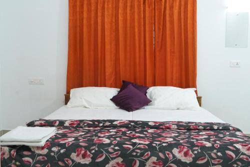 a bedroom with a bed with a floweridered comforter at Pearl Inn in Kottakkal