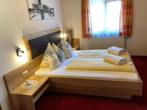 a bedroom with a large bed with pillows on it at Rieserhof/Fam. Meißnitzer in Taxenbach