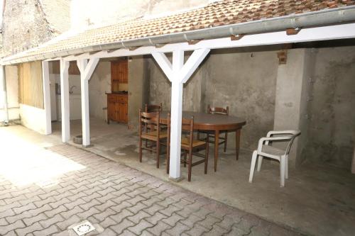 un patio avec une table et des chaises sous un pavillon dans l'établissement Les Volets Bleus, à Pierrefitte-sur-Loire