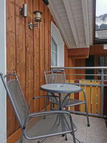 a table and two chairs on a balcony at Landhaus Thaler in Mittelberg