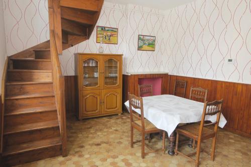 um quarto com uma mesa e cadeiras e uma escada em Les Volets Bleus em Pierrefitte-sur-Loire