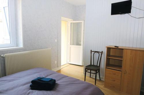 um quarto com uma cama, uma secretária e uma cadeira em Les Volets Bleus em Pierrefitte-sur-Loire
