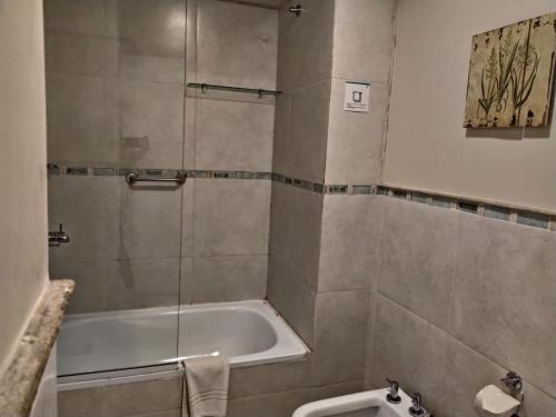 y baño con bañera, aseo y lavamanos. en Departamentos Illia By Lugar en Córdoba