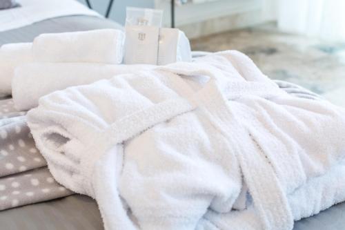 a pile of white towels on a bed at 4 Star Bologna Train Station - Self Check-In in Bologna
