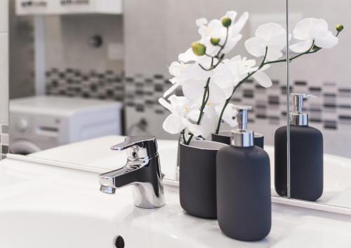 a bathroom counter with two soap bottles and a mirror at 4 Star Bologna Train Station - Self Check-In in Bologna