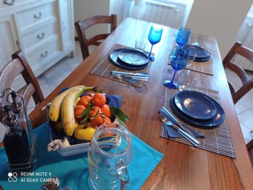 a wooden table with a plate of fruit on it at CASA DELLE API in Pisogne