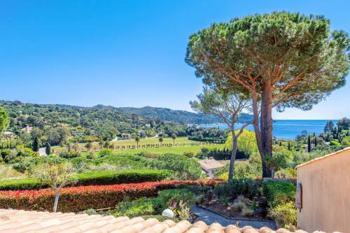 Elle offre une vue sur un jardin avec un arbre et l'océan. dans l'établissement Appartement Moorea - Welkeys, à La Croix-Valmer