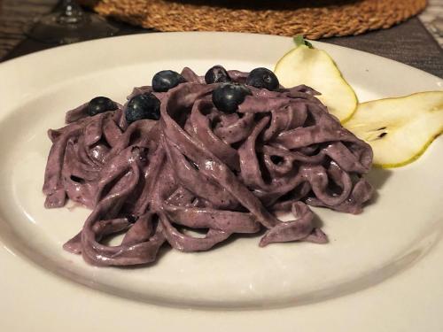 a plate of food with meat and blueberries on it at Baita Dal Vikingo in Sorico