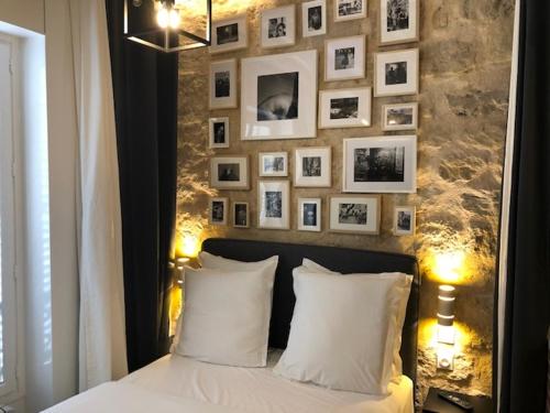- une chambre dotée d'un lit avec des oreillers blancs et des photos murales dans l'établissement Appartement Aix, Neuf tout équipé, à Paris