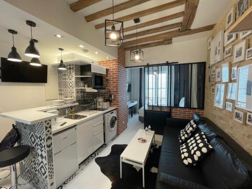 une cuisine et un salon avec un canapé et une table dans l'établissement Appartement Aix, Neuf tout équipé, à Paris