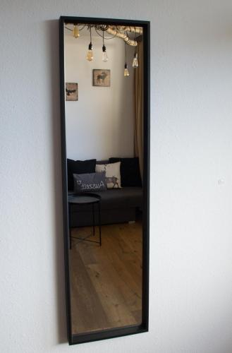 a mirror on a wall with a couch in a room at Apartment Noemi in Bad Goisern