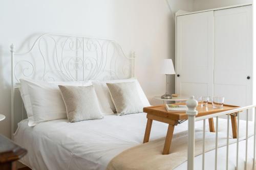 - une chambre avec un lit blanc et une table en bois dans l'établissement Rose Apartment by Quokka 360 - refined two-bedroom apartment with garden, à Lugano