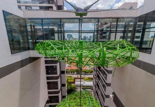 a green sculpture hanging from the side of a building at Magníficos Ap Luxo - 43mts e 63mts, 1 ou 2 Qtos in São Paulo