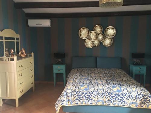 sypialnia z łóżkiem, komodą i dwoma stołami w obiekcie La stanza delle Muse in Villa con Piscina w mieście Fontane Bianche