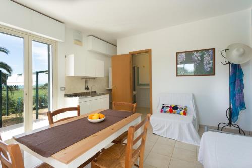 a kitchen and dining room with a table and chairs at Al Ficodindia in Sampieri