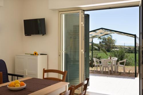 a dining room with a sliding glass door to a patio at Al Ficodindia in Sampieri