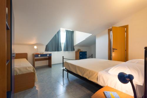 a bedroom with two beds and a desk and a window at Al Ficodindia in Sampieri