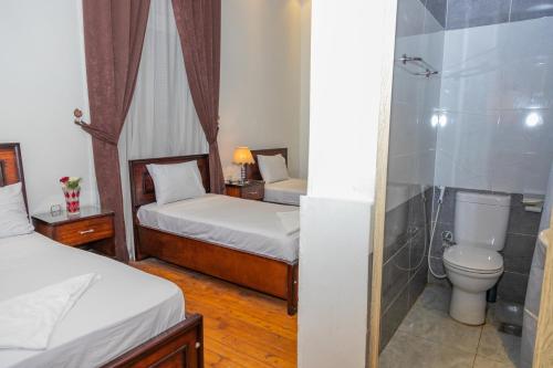 een slaapkamer met 2 bedden, een douche en een toilet bij Regency inn in Caïro