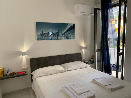 a bedroom with a bed with two towels on it at Cala Gonone - Casa del Mirto in Cala Gonone