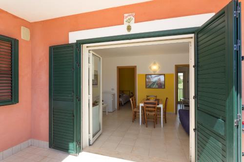 a room with a door open to a dining room at Al Ficodindia in Sampieri