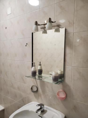 un baño con lavabo y espejo en Piso termal, en Ourense