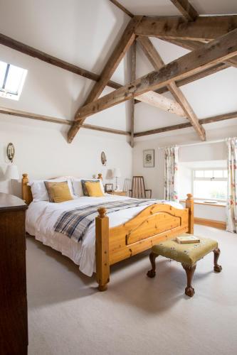 a bedroom with a large wooden bed and a table at Cragend Grange in Rothbury