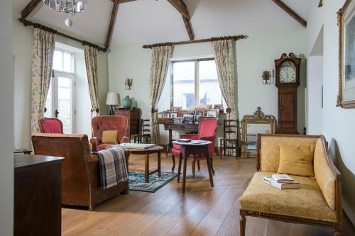 a living room with furniture and a clock on the wall at Cragend Grange in Rothbury