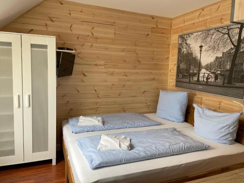 two beds in a room with wooden walls at Lindenhof Habernis in Steinberg
