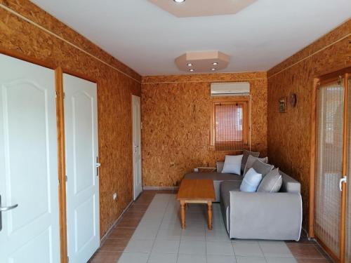 Ljubovija的住宿－VIKENDICA ODMOR NA DRINI，客厅配有沙发和桌子