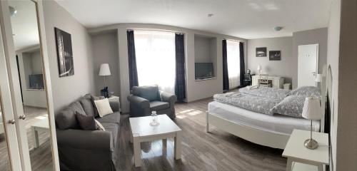 ein Wohnzimmer mit einem Bett und einem Sofa in der Unterkunft Gasthaus Hafenblick in Tönning