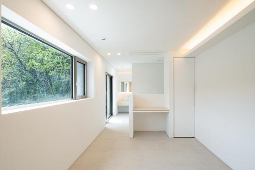 a hallway with white walls and a large window at Laon on 37 in Tongyeong