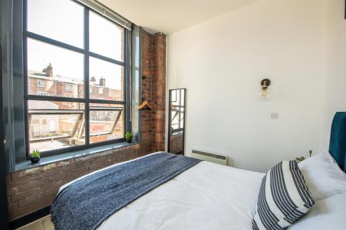 a bedroom with a bed and a large window at Proform Property Apartments in Liverpool