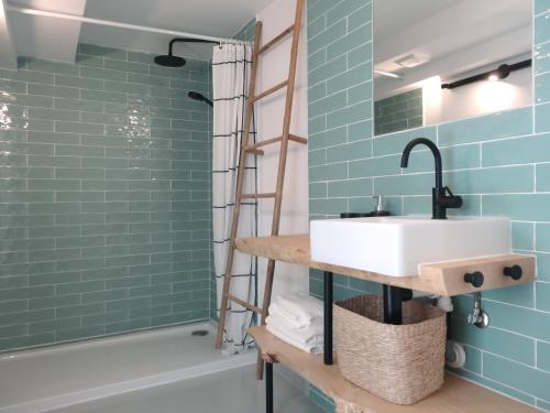 a bathroom with a sink and a shower with blue tiles at Surf & Kite - Villa Nortada in Charneca