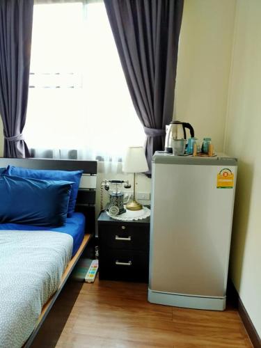 a room with a bed and a refrigerator next to a window at The Cube Sathorn Boutique Hotel เดอะ คิวบ์ สาทร บูติค โฮเทล Near BTS Surasak in Bangkok