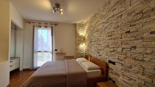 Un dormitorio con una pared de piedra y una cama en ANTICA PREARA, en Breganze