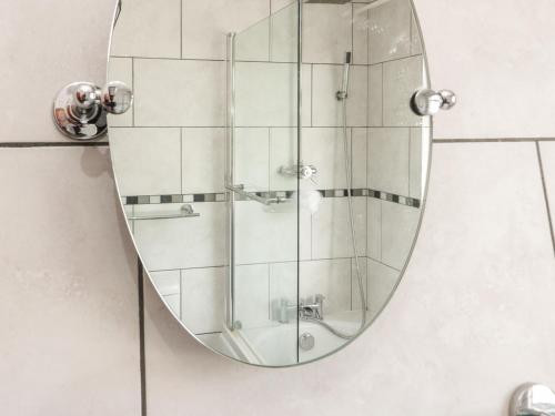 a mirror on a wall in a bathroom at Gorwelion in Holyhead