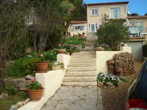 - un jardin fleuri et des escaliers en face d'une maison dans l'établissement la meridienne, à Sète