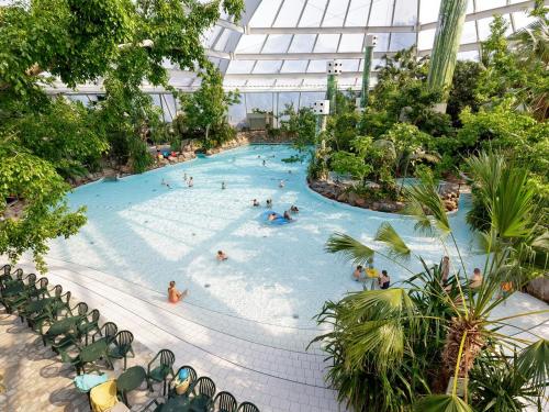 a group of people in a swimming pool in a building at Hotel Het Heijderbos by Center Parcs in Heijen