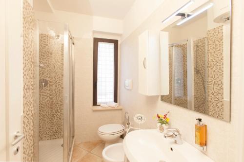 bagno bianco con servizi igienici e lavandino di Agriturismo Colle Oliveto a Orbetello