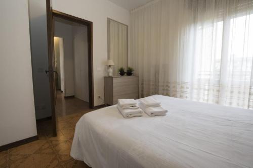 een witte slaapkamer met 2 handdoeken op een bed bij Mary Rose Apartment in Vicenza