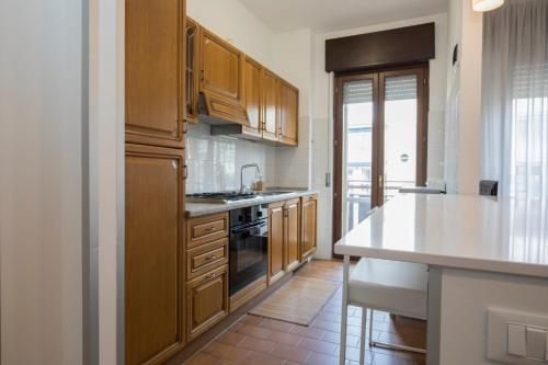 a kitchen with wooden cabinets and a white counter top at Mary Rose Apartment in Vicenza