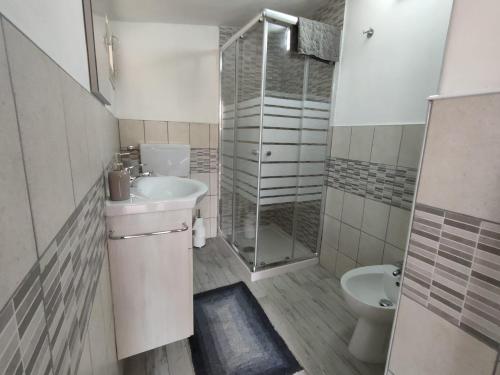a bathroom with a shower and a sink and a toilet at Casa Peloritani in Siracusa