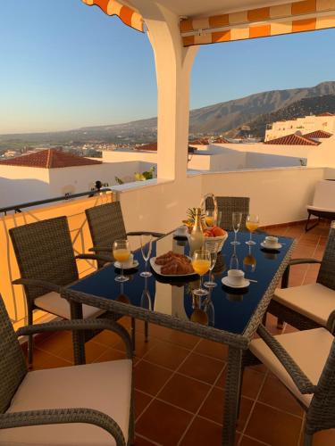 uma mesa com copos de vinho numa varanda com vista em Duplex Penthouse Panoramic Del Atlantico em Adeje