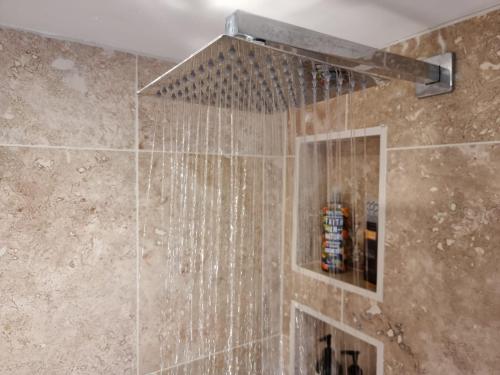 a bathroom with a shower with a shower head at Willow House B&B in West Wittering