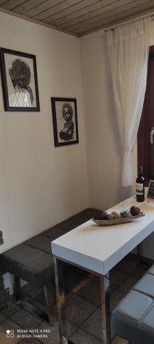 a white table in a room with two pictures on the wall at Ferienhaus im Ederbergland in Hatzfeld