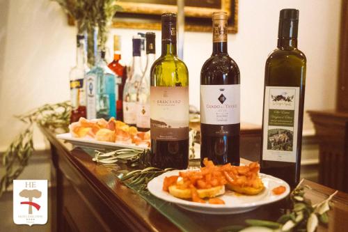 two bottles of wine and two plates of food on a counter at Hotel Executive in Florence