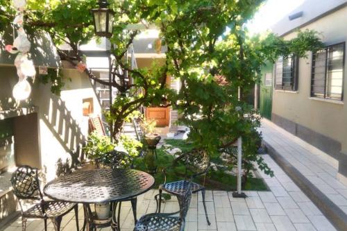 a patio with a table and chairs and a tree at Chalet interno con rooftop in Villa Carlos Paz