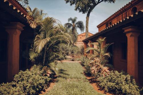 un jardín con palmeras y un edificio en Hotel Guaminí Misión en Puerto Iguazú